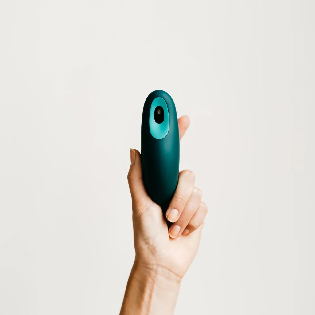 Hand holding the Blue Green Moonbird breathing device